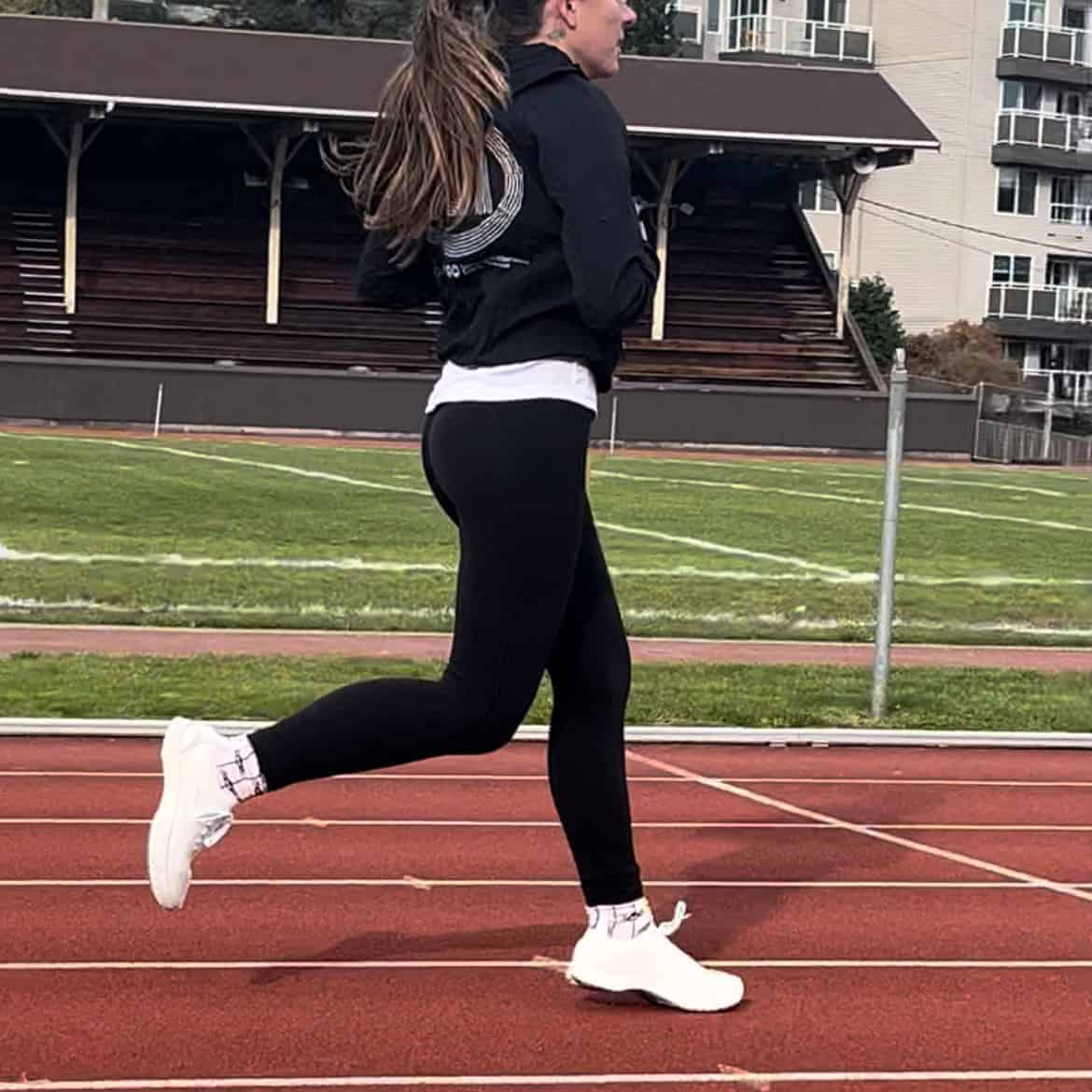 Woman running in Antepes Muscle Runner shoes on a track.