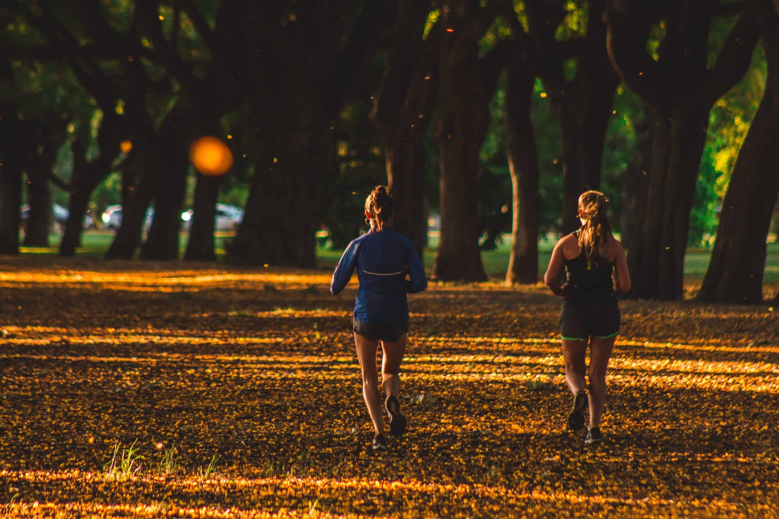 Two women running in the park at a slow pace part of polarized training.