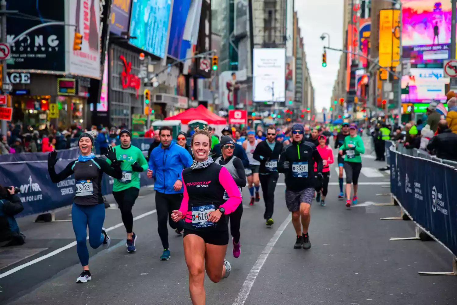 Runners participate in a marathon through a bustling city street